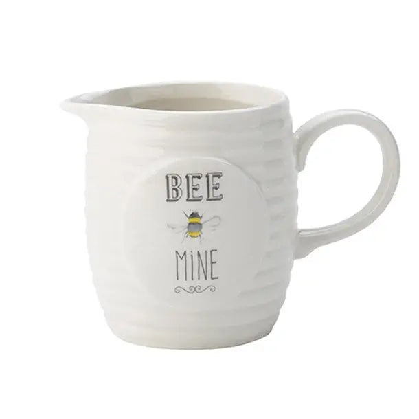 A white ceramic creamer jug with the words Bee Mine on the front