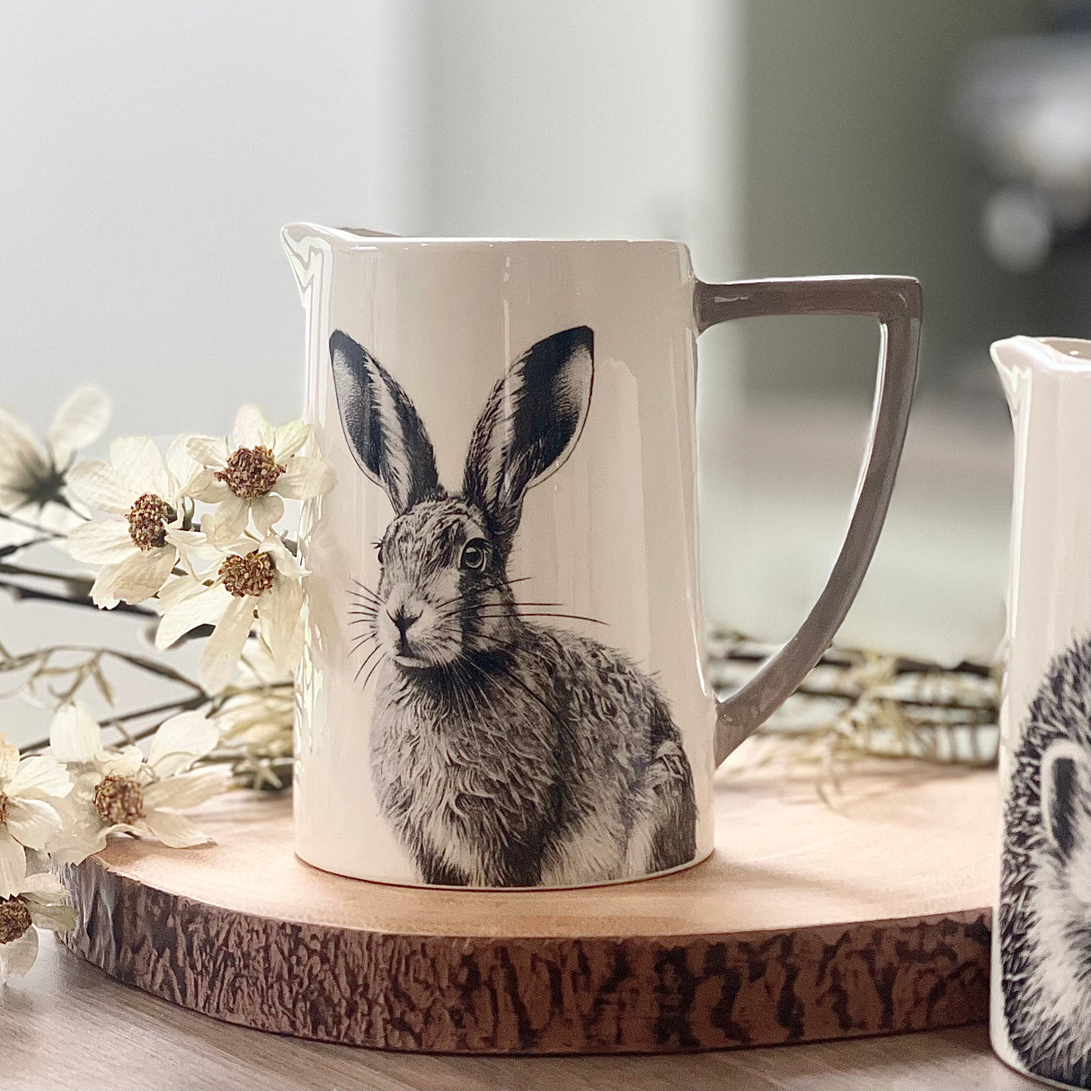 A white Jug featuring a pencil drawing of a Hare and a grey handle