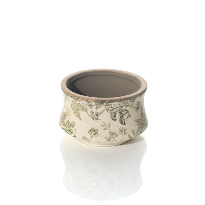 A small round ceramic planter with a green floral pattern and a beige rim, shown on a reflective white surface against a white background