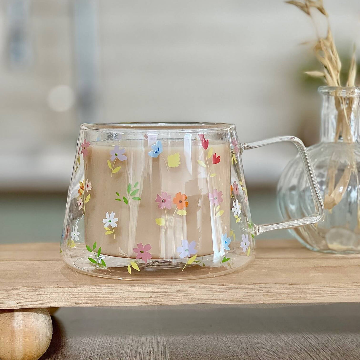 A double wall glass mug with a flower design - showing with tea