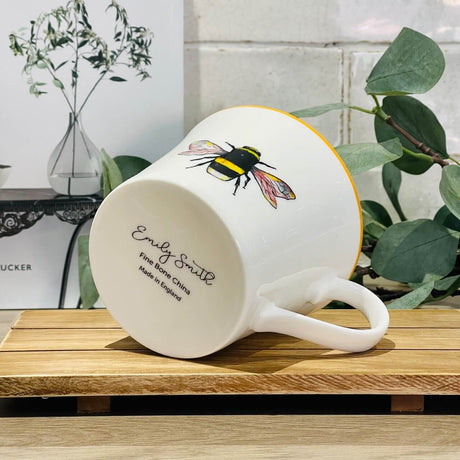 Bone China Mug with a Bee design that is placed on it's side showing "Emily Smith" as the designer