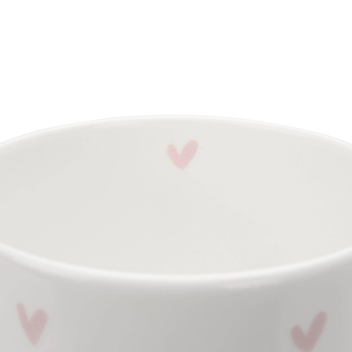 A close up of a white ceramic fine bone china mug with pink heart patterns on a white background