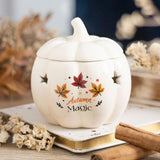 White ceramic pumpkin with 'Autumn Magic' text and leaf designs on a blurred background