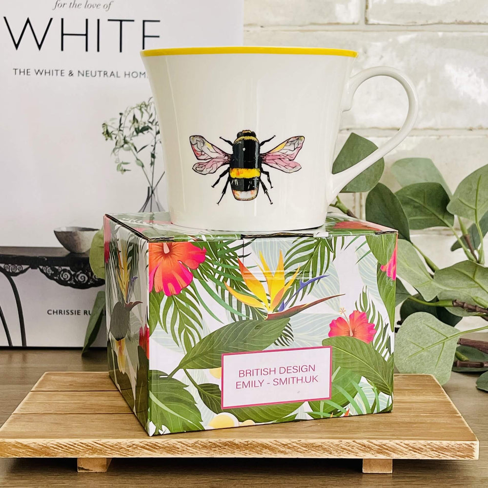 Bone China Mug with a Bee Design, placed on a multi coloured box