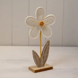 Decorative flower sculpture on a stand with a plain background
