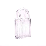Clear glass handbag vase on a white background