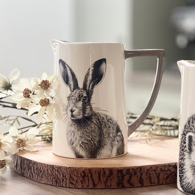 A white Jug featuring a pencil drawing of a Hare and a grey handle