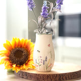 Decorative vase with flowers on a wooden surface