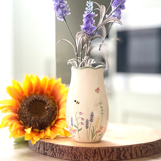 Decorative vase with flowers on a wooden surface