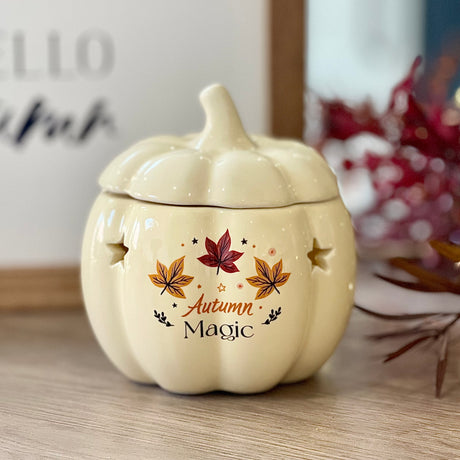 Ceramic pumpkin-shaped container with 'Autumn Magic' text and leaf designs 