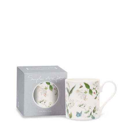 A white fine bone china mug with a delicate floral and butterfly print, displayed next to its gray presentation box on a clean white background.
